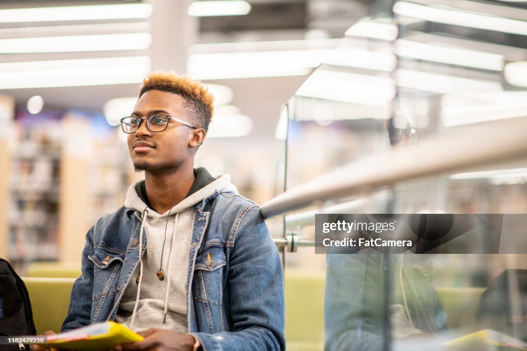 Un étudiant afro-américain étudiant dans la photo stock de bibliothèque