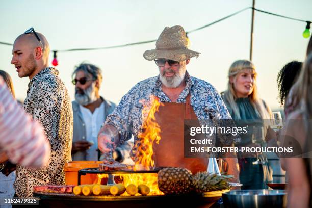 grill chef is grilling meat on a barbecue grill outdoors - grill fire meat stockfoto's en -beelden