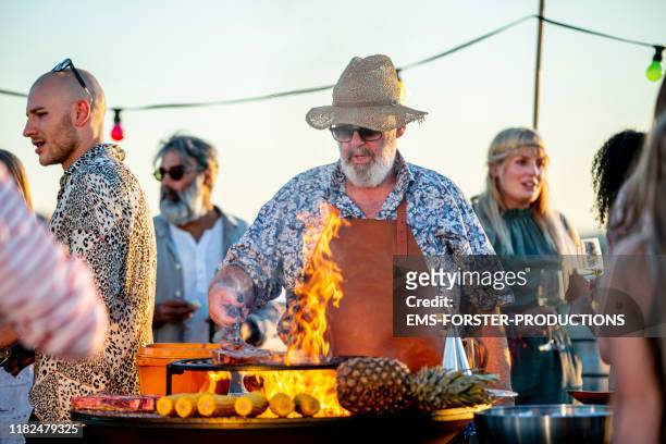 grill chef is grilling meat on a barbecue grill outdoors - rooftop bbq stock pictures, royalty-free photos & images