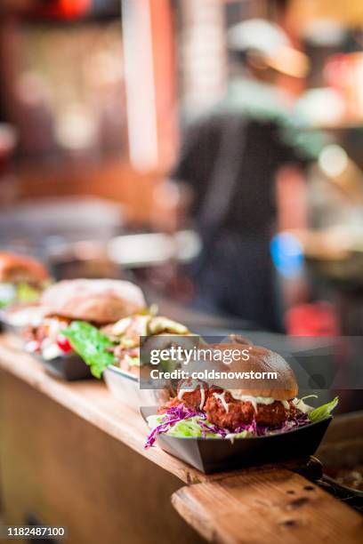 fresh flame grilled burgers displayed in a row at food market - chef market stock pictures, royalty-free photos & images