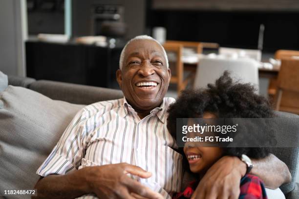 grandfather and granddaughter playing with smartphone - grandfather stock pictures, royalty-free photos & images