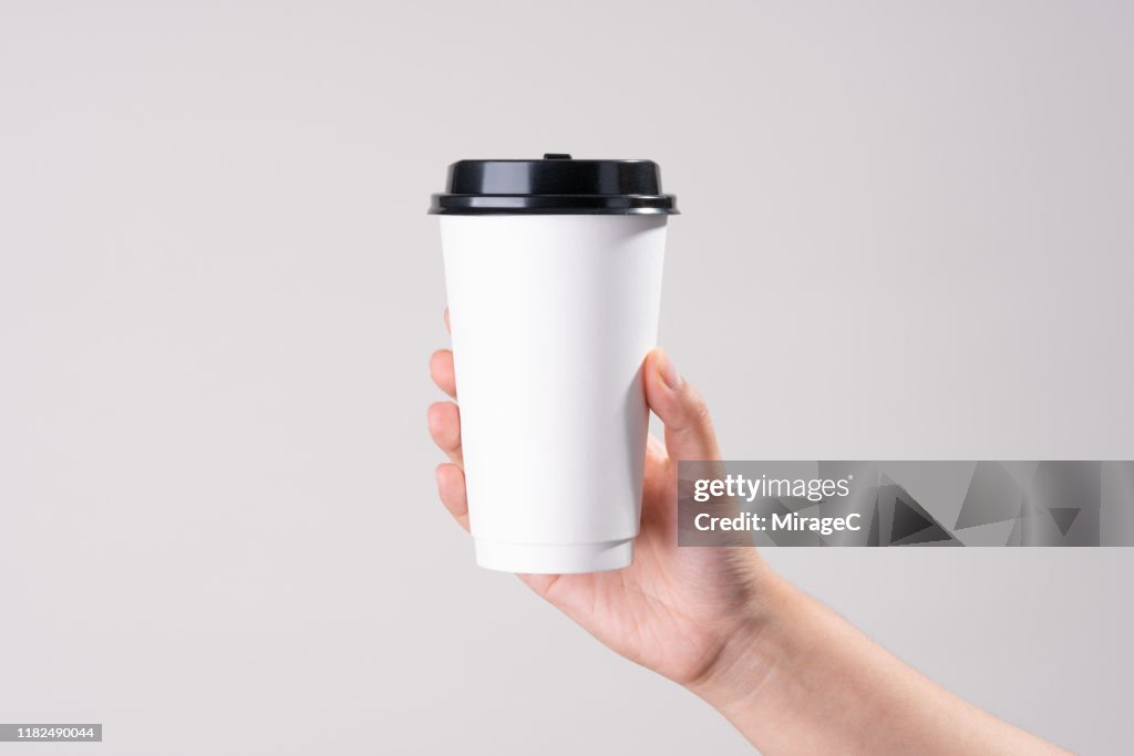 Hand Holding White Paper Cup