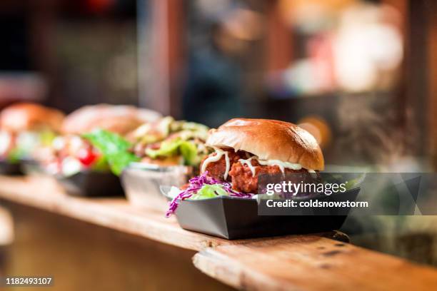 hamburger di maiale croccanti freschi di fila al mercato alimentare - cibo precotto foto e immagini stock
