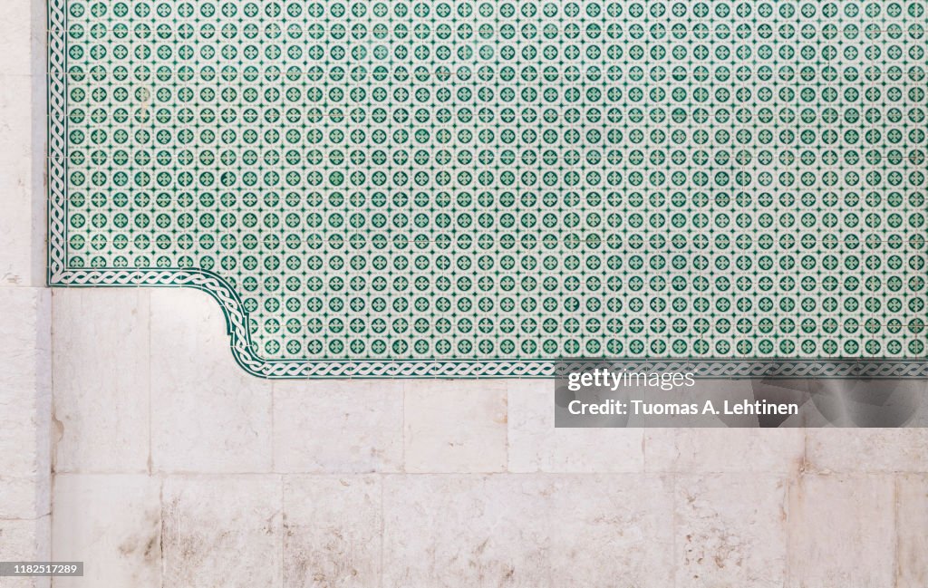Old stone wall and green ceramic tiles (azulejos) in Lisbon, Portugal. High resolution full frame textured background.