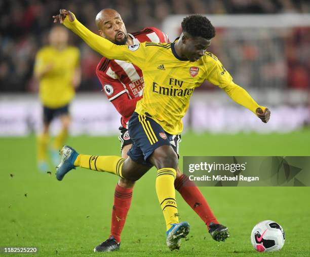 David McGoldrick of Sheffield United battles for possession with Bukayo Saka of Arsenal during the Premier League match between Sheffield United and...