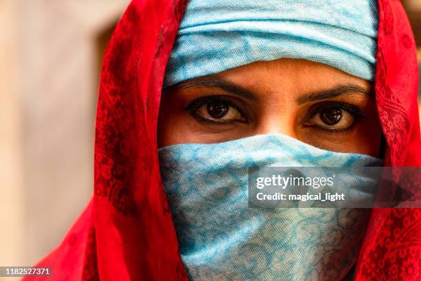 portret in de sjaal. oost-vrouw een portret, jonge midden-oosterse vrouw in hijab met sexy zwarte ogen. mooie brunette vrouw in rode en blauwe hoofddoek - niqab stockfoto's en -beelden