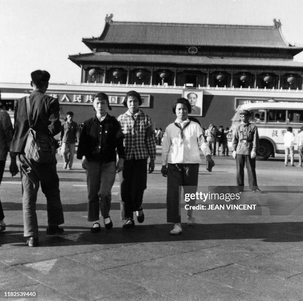 Young Chinese Red Guards stroll on Tienanmen Square in Beijing in August 1966 with a portrait of Chairman Mao Zedong in the background during the...