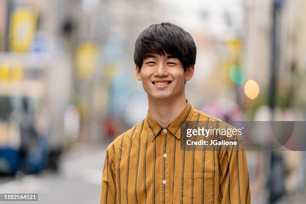 portrait of a confident young man outdoors on the street - 20s stock pictures, royalty-free photos & images