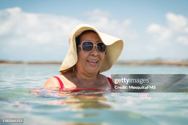 grandma swimming on the tropical beach - beach hat stock pictures, royalty-free photos & images