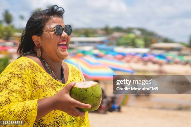 woman drinking coconut water at tropical beach - coconut beach woman stock pictures, royalty-free photos & images