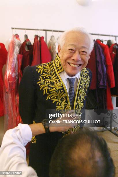 Un membre de la maison de couture Sorbier, vérifie le 07 novembre 2003 à Paris, les dernières finitions sur l'habit d'académicien de Zao Wou-Ki ,...