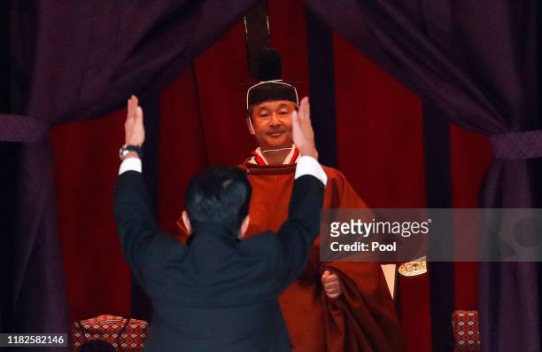 Japan's Prime Minister Shinzo Abe raises his hands as he shouts “banzai” or cheers in front of Emperor Naruhito during a ceremony to proclaim Emperor...
