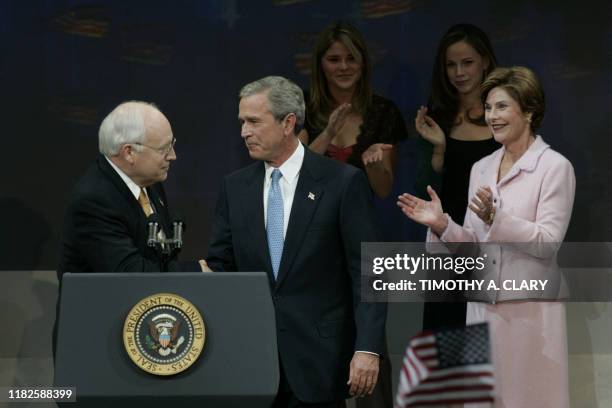 President George W. Bush shakes the hand of US Vice President Dick Cheney as his wife Laura and daughters Jenna and Barbara look on, after his...