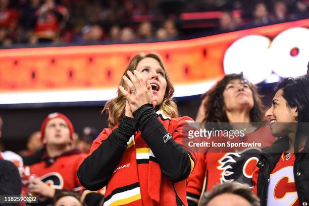 Calgary Flames fan celebrates a goal by her team during the third period of an NHL game where the Calgary Flames hosted the Dallas Stars on November...