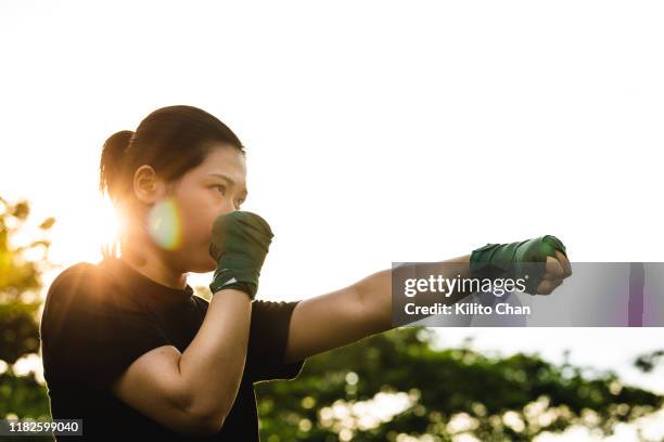 asian female practicing mixed martial art outdoor - mixed boxing stock-fotos und bilder