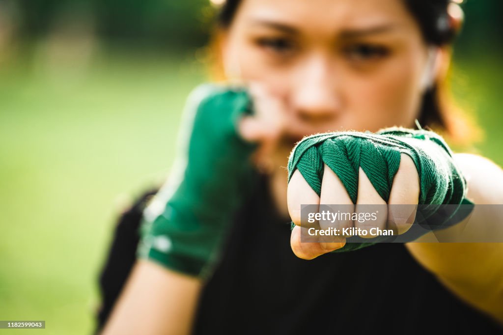 Asian female practicing mixed martial art outdoor
