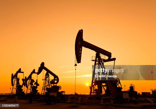 oil pumps and rig at sunset - petroleum industry stock pictures, royalty-free photos & images