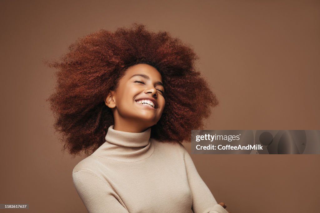 Photo de fille bouclée gaie avec des émotions positives