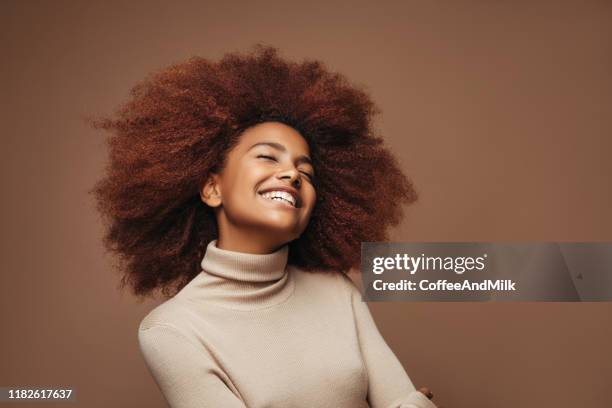 foto van vrolijke krullend meisje met positieve emoties - hairdressers black woman stockfoto's en -beelden