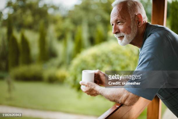 smiling mature man enjoying in morning coffee on a terrace. - coffee on patio stock pictures, royalty-free photos & images