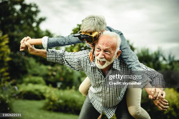 zorgeloos senior paar met plezier terwijl meeliftende in de natuur. - flying goggles stockfoto's en -beelden