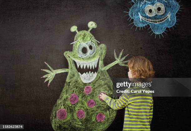 little boy drawing a virus on chalkboard - very scary monsters stock-fotos und bilder