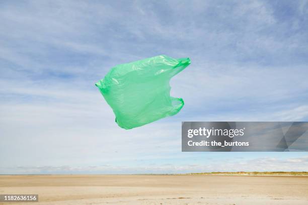 plastic bag flying in the wind on the beach against sky - beach bag bildbanksfoton och bilder