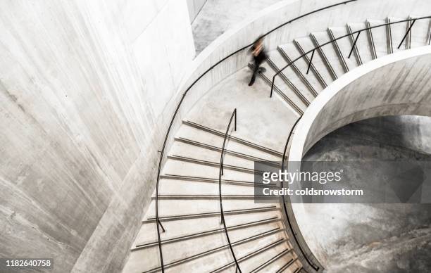 blurred motion of person on spiral staircase - upward curve stock pictures, royalty-free photos & images