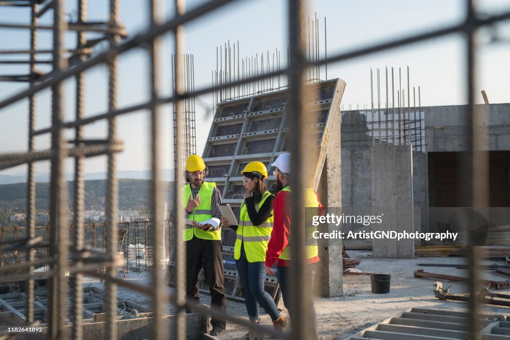 Los trabajadores de la construcción discuten los planes de construcción.