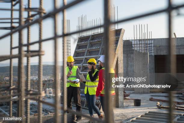 bouwarbeiders bespreken de bouwplannen. - construction site tech stockfoto's en -beelden