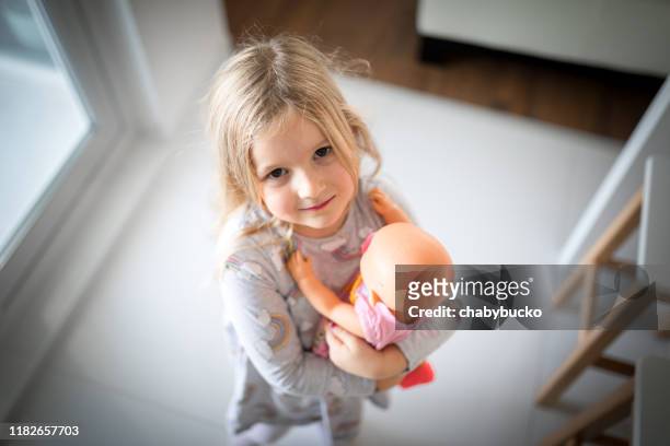 liten flicka bär hennes kärleksfulla docka - doll bildbanksfoton och bilder