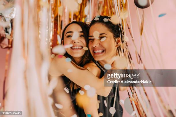 lächelnde freundinnen auf der party - girlfriends party stock-fotos und bilder