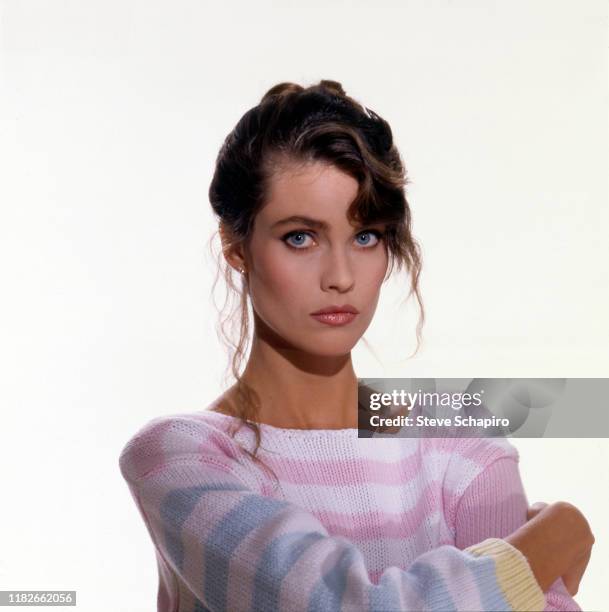 Portrait of American model and actress Carol Alt, in a blue, pink, and white sweater, as she poses against a white background, Los Angeles,...