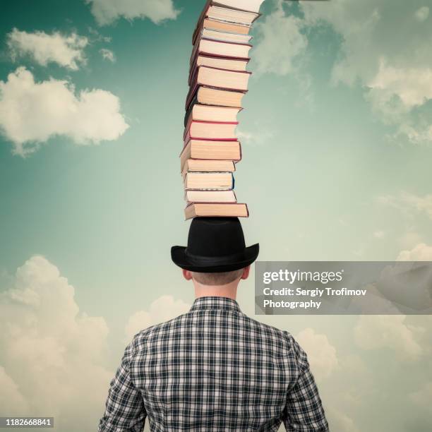 books stack on head of man in hat, education concept - carregar na cabeça - fotografias e filmes do acervo