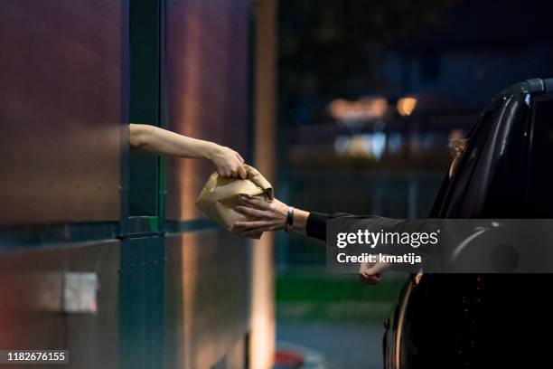 customer receiving food at drive thru - take out food imagens e fotografias de stock