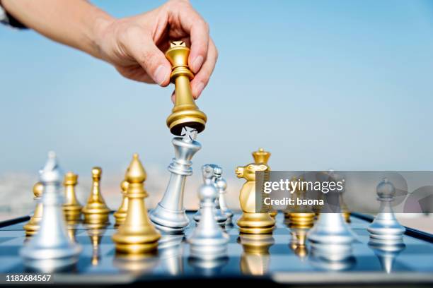 man hand bewegende gouden koning in schaakspel - chess game stockfoto's en -beelden