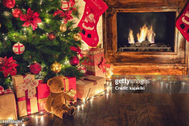 regalos envueltos bajo el árbol de navidad en un ambiente festivo acogedor - debajo de fotografías e imágenes de stock