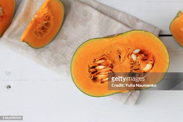 group of halves and whole pumpkin on a light wooden background. pumpkin is not cleared of seeds. - honda center fotografías e imágenes de stock
