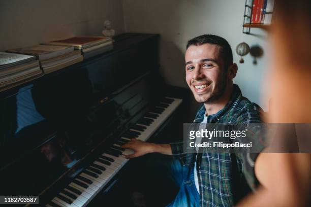 jonge volwassen pianist die thuis een selfie neemt - klavier stockfoto's en -beelden