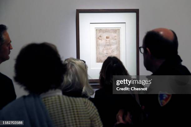 Visitors look at the drawing entitled 'The Vitruvian Man' by the Italian Renaissance artist, Leonardo da Vinci, during a press visit of the...