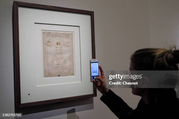 Visitor takes a picture of the drawing entitled 'The Vitruvian Man' by the Italian Renaissance artist, Leonardo da Vinci, during a press visit of the...