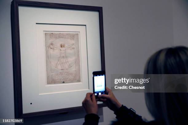 Visitor takes a picture of the drawing entitled 'The Vitruvian Man' by the Italian Renaissance artist, Leonardo da Vinci, during a press visit of the...
