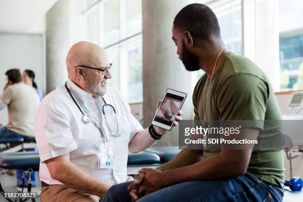 mogen läkare och patient titta på tablet pc-skärmen - outpatient care bildbanksfoton och bilder