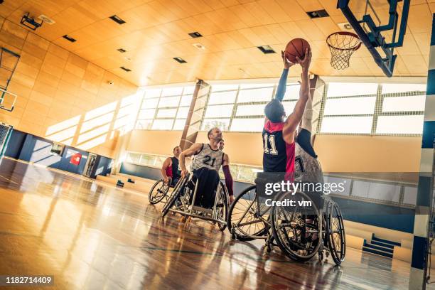 proberen een blok tijdens een rolstoel basketbal spel - basketbal teamsport stockfoto's en -beelden