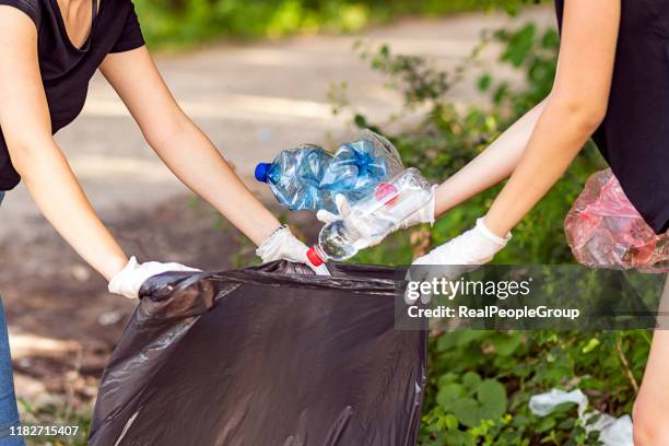 frau hand holt müll plastik für die reinigung im park - pick rubbish stock-fotos und bilder