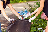 Woman hand picking up garbage plastic for cleaning at park