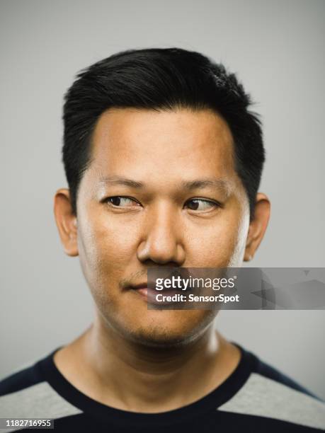 hombre malayo real con expresión en blanco mirando a un lado - mirada de reojo fotografías e imágenes de stock