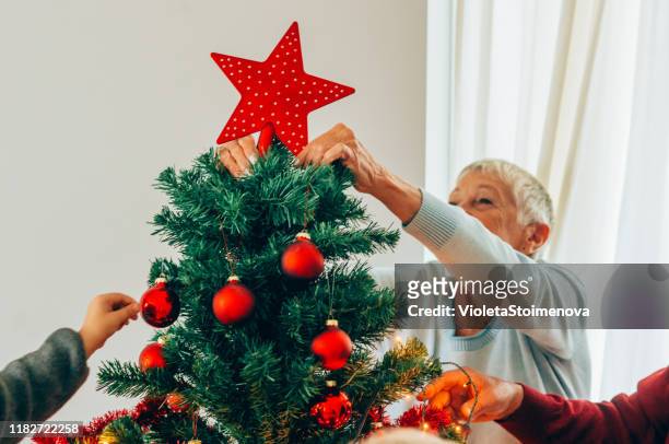 senior woman decorating the christmas tree - christmas angel stock pictures, royalty-free photos & images