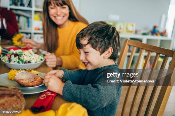 glückliche mutter und ihr sohn spaßig beim essen truthahn bein - chicken decoration stock-fotos und bilder