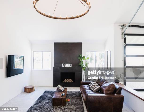 living room with leather sofa and fireplace - fitting stockfoto's en -beelden